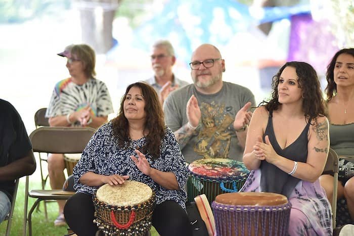 People engaged in a drum circle, creating rhythms and enjoying the communal experience of drumming.